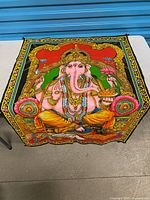 Full view of square Ganesha tapestry on table