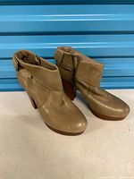 Side view of both boots showing leather uppers, block heels, overall condition