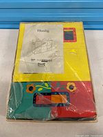 Box containing colourful flat-pack panels of Huslig unit with manual on top