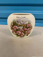 Front of vase showing painted Jasper, Canada scene and flowers
