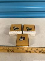 Three boxed candle sets with ruler for scale