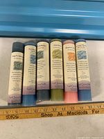 Front view of six coloured ritual candles with labels