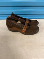 Side view of both shoes showing uppers, straps, and outsoles