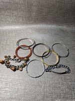 All eight bracelets laid out showing variety of styles