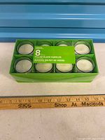 Top view of boxed set showing 8 white candles in glass holders