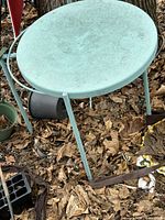 Top view showing round turquoise metal surface and legs