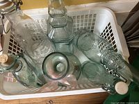 Basket containing several aqua glass bottles and decanters