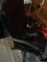 Full side view of black faux leather office chair showing armrest, seat and back