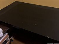 Overall view of black desk top showing surface wear