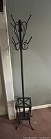 full view of black metal coat rack with umbrella stand