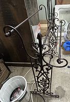 Front view of cast iron towel rack showing three bars and ornate scrollwork