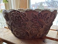 Side view showing embossed floral pattern and brown wash finish