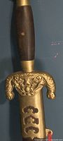 close view of brass dragon-motif guard and wood grip
