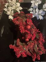 Entire lot showing red garland and two white poinsettia candle rings in storage bin