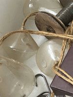 group of clear glass planters with jute cords and metal hooks