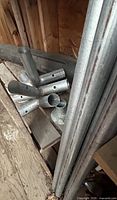 Stack of short galvanized pipe connectors with holes, and ends of long pipes