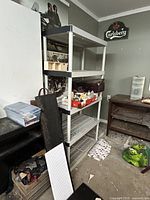 Full view of gray plastic 5-tier shelving containing miscellaneous items