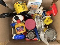 Box containing various cleaning supplies, wax tin, polish bottle, spray bottles, gloves and small containers