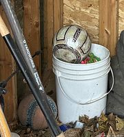 White bucket with soccer ball and small plastic toys