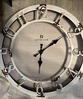 Front view showing full clock face, numerals, brand logo