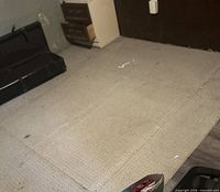 Full view of beige/tan area rug remnant laid on floor showing overall size and wear