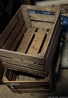 Two stacked weathered wooden slat crates showing sides and bottom slats
