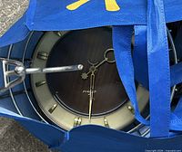 Clock inside blue bag showing full wooden face and brass details