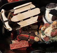 Overall view showing sled, penguin, Santa figurines, tin and sign in lot