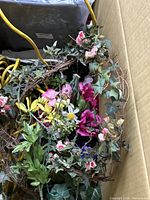 Cardboard box containing silk floral garland with ivy, roses, daisies and loose flower stems