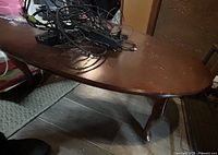 Top view of oval coffee table showing dark brown veneer surface with scratches