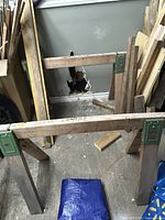 Pair of wooden sawhorses showing overall structure and green metal brackets