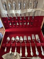 Flatware set in open chest showing knives in lid and utensils in tray