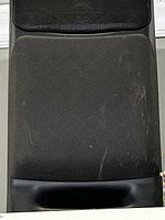 Front view of one speaker showing fabric grill and wear marks