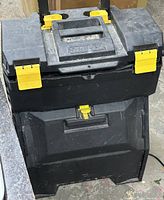 Front view of Stanley rolling toolbox chest showing yellow latches and telescoping handle