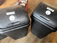 Front view of both black SwingTop bins with lids