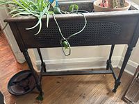 Full view of planter box on stand showing legs and cane panel