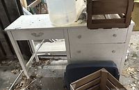 Front view of white distressed desk with jug and crates on top