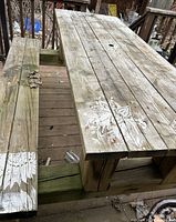 Top and one bench of wood picnic table showing weathered surface and stencil paint