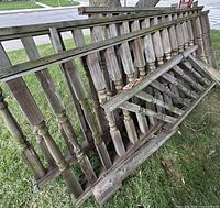 Stacked wood porch railing sections showing turned balusters