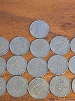 Group layout of all 16 one shilling coins, obverse and reverse visible