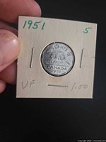 Reverse of 1951 5-cent coin in cardboard 2×2 holder, date and refinery design visible