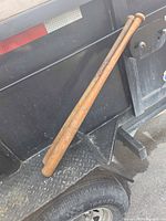 Two wooden bats leaning against trailer showing full length