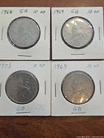 Four 10 New Pence coins in holders showing years 1968, 1969, 1973