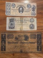 Fronts of three reproduction notes showing denominations $5, $500, $1000