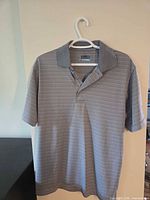 Full front view of gray PGA Tour polo shirt on hanger