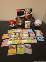 All items together: cards spread out, four tins, binder, surprise box