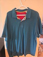 Front view of teal Robert Graham polo on hanger