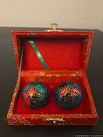 Two cloisonné Baoding balls inside red brocade box