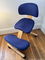 Front three-quarter view showing blue upholstery, wooden frame, casters, backrest