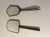Front of both handheld mirrors showing mirror glass surfaces